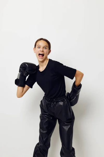 Atlético mulher no preto esportes uniforme boxe luvas posando isolado fundo — Fotografia de Stock