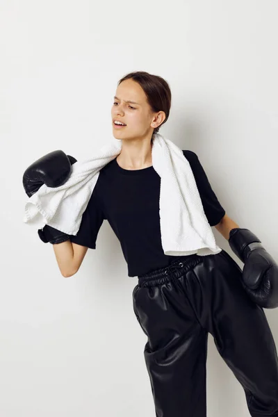 Hermosa chica en guantes de boxeo en pantalones negros y una camiseta estilo de vida inalterable —  Fotos de Stock