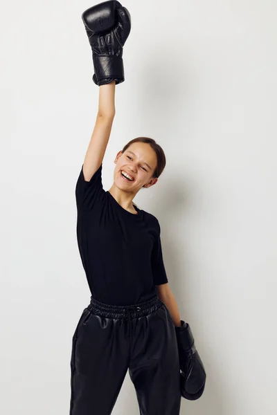 Jong mooi vrouw in zwart sport uniform bokshandschoenen poseren geïsoleerde achtergrond — Stockfoto