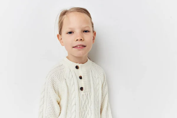 Маленька дівчинка білий светр рука жести світлого фону — стокове фото