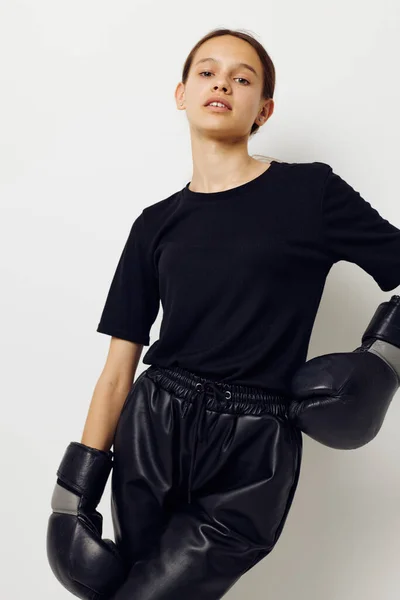 Ung kvinna i boxningshandskar i svarta byxor och en T-shirt isolerad bakgrund — Stockfoto