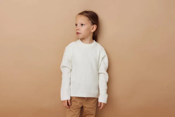 Kleines Mädchen im weißen Pullover posiert mit Handgesten Lebensstil unverändert — Stockfoto