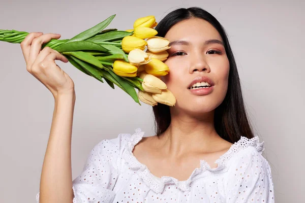 Žena s asijským vzhledem romantika kytice květin v blízkosti obličeje životní styl beze změny — Stock fotografie