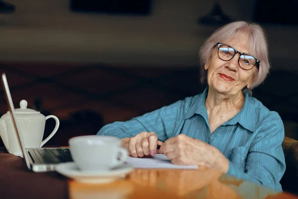 Retrato de una anciana que trabaja delante del monitor del ordenador portátil sentado Estilo de vida inalterado — Foto de Stock