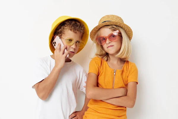 Chico y chica de moda con gafas posando entretenimiento telefónico — Foto de Stock