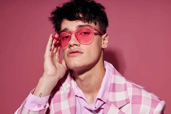 Красивий чоловік в рожевих окулярах рожевий блейзер позує студію ізольований фон незмінний — стокове фото