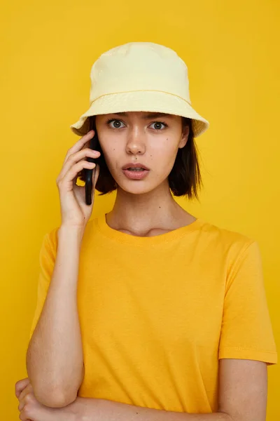 楽観的な若いです女性でA黄色の帽子若者スタイルカジュアルなトーク上の電話ライフスタイル変更なし — ストック写真
