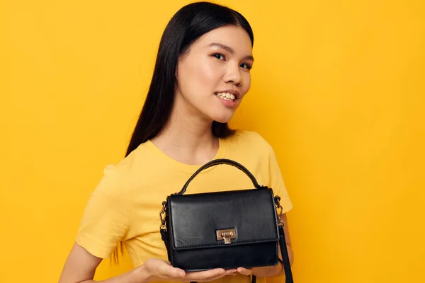 Vacker brunett med en svart kvinna väska i händerna studio modell oförändrad — Stockfoto