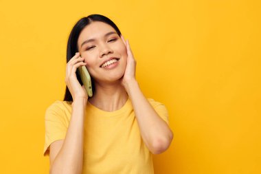 Güzel esmer telefon iletişimi eğlenceli sarı arkaplan kullanın