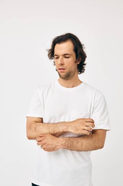 Beyaz tişörtlü çekici bir adam. El hareketi. Yaşam tarzı değişmemiş.