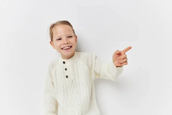 Malá dívka bílá svetr ruka gesta světlo pozadí — Stock fotografie