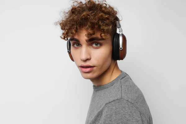 Красивий хлопець слухає музику в навушниках емоції світлого фону — стокове фото