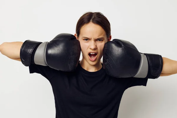 Mulher atlética em luvas de boxe em calças pretas e um treinamento de fitness t-shirt — Fotografia de Stock