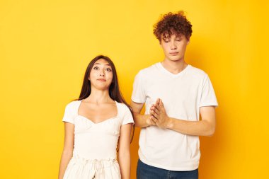 Beyaz tişörtlerle poz veren bir erkek ve kadının portresi. Dostluk. Değişmemiş yaşam tarzı.