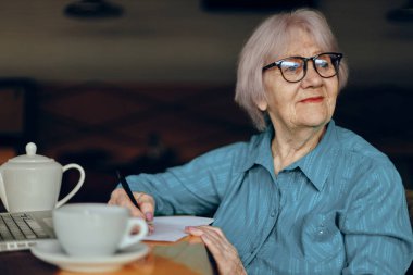 Bir kafede bir iş kadını bir bardak içki, dizüstü bilgisayar Freelancer değişmeden çalışır.