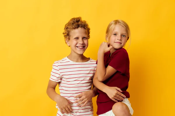 평범 한 소년 소녀들은 노란 배경을 가진 재미있는 놀이를 한다 — 스톡 사진