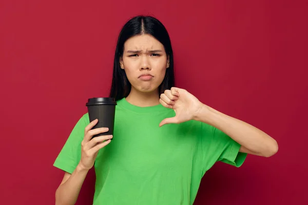 Mujer en una camiseta verde de cristal negro con una bebida disgusto — Foto de Stock