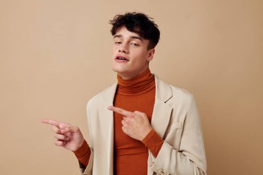 Elinde telefonuyla poz veren genç bir adam zarif bir ceketle hayat tarzını değiştirmemiş.