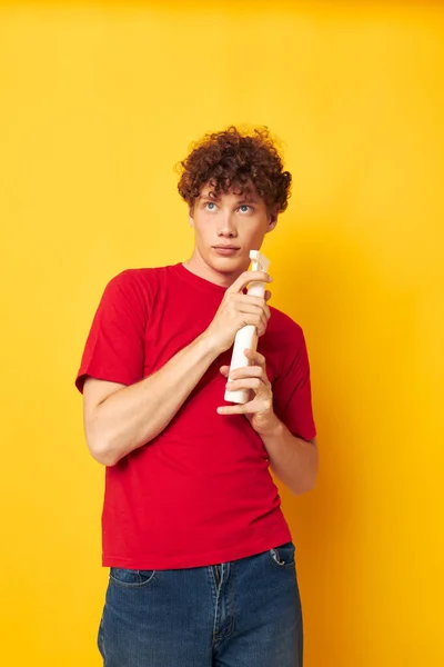 若いです巻き毛の男で赤いTシャツの洗剤で手をポーズモノクロショット — ストック写真