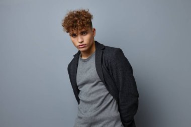 Yakışıklı genç adam seksi poz veren ceketin kendine güveni soyutlanmış arka plan