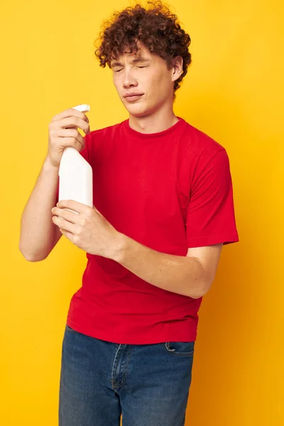 Молодий кучерявий чоловік миючий засіб для дому позує ізольований фон незмінним — стокове фото