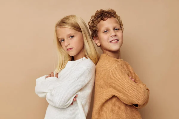 Niño y niña de pie junto a posar emociones de fondo beige — Foto de Stock