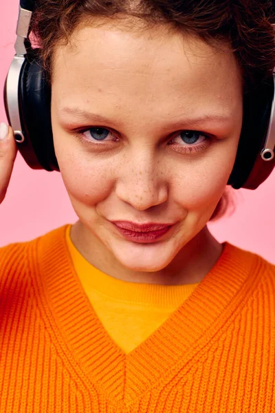 Cheerful woman in an orange sweater headphones music entertainment cropped view unaltered — Stock Photo, Image