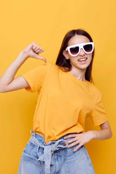 Beautiful girl with long hair wearing sunglasses posing yellow background — Stock Photo, Image