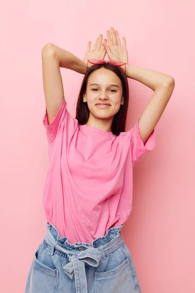 Jovem mulher bonita em uma camiseta rosa roupas casuais fundo rosa — Fotografia de Stock