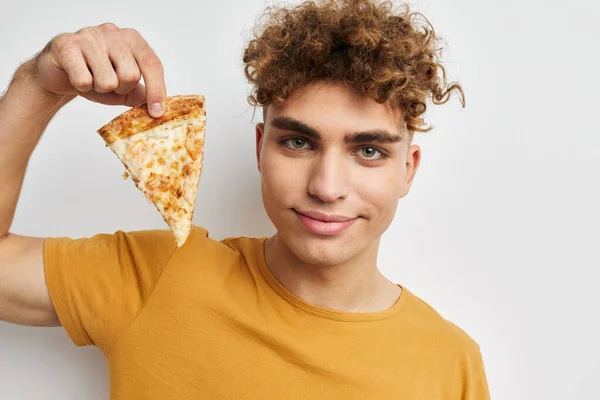Привабливий чоловік їсть піцу, позує крупним планом ізольований фон — стокове фото