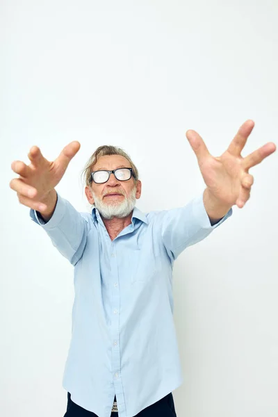 Photo du vieil homme à la retraite en chemises bleues gestes avec ses mains fond isolé — Photo