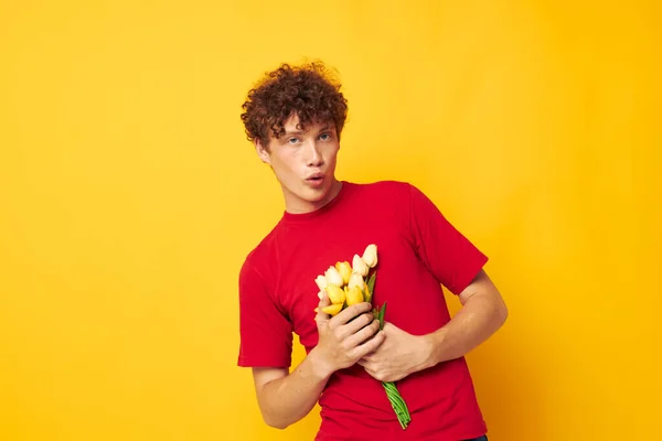 Guy with red curly hair romantic posing with a yellow bouquet of flowers isolated background unaltered — Stock fotografie