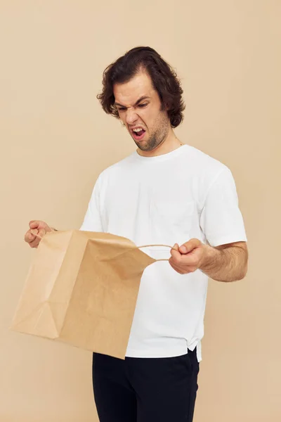 Veselý muž papír potraviny taška představuje izolované pozadí — Stock fotografie