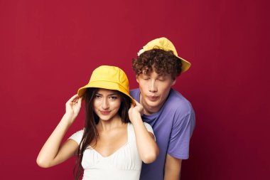 Genç bir çift yan yana durur. Moda tarzı modern ev tarzı. Eğlenceli, izole bir arka plan.