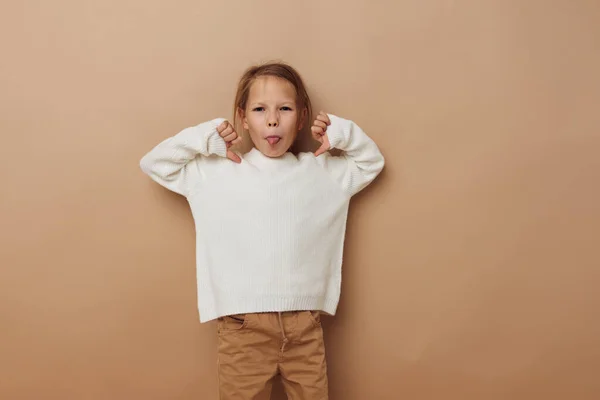 Маленькая девочка в белом свитере позирует жесты руки изолированный фон — стоковое фото