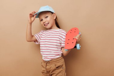 Elinde kaykayla gezen tatlı bir kız. Gülümsüyor. Hayat tarzını değiştirmemiş.