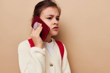 Portrait of happy smiling child girl schoolgirl backpack phone in hand childhood unaltered