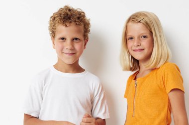 Küçük çocuklar günlük kıyafetlerini giyiyorlar. Stüdyo, arka planı değiştirilmemiş.