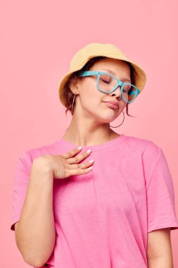 Panama şapkalı ve gözlüklü genç bir kadın izole bir arka plan oluşturuyor.