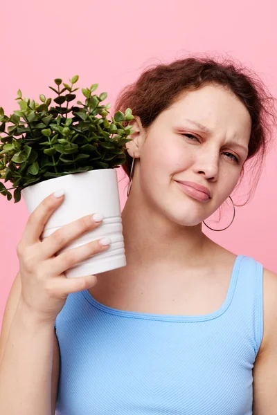 Retrato de una mujer joven sosteniendo una olla con una flor aislada fondos inalterados — Foto de Stock
