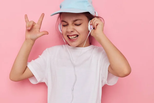 Portrait of happy smiling child girl listening to music on headphones isolated background — Stock Photo, Image