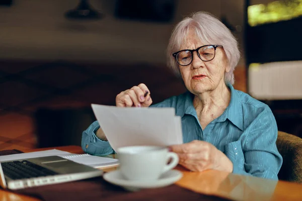 Anciana que trabaja delante del monitor del ordenador portátil sentado Mujer jubilada charlando inalterada — Foto de Stock