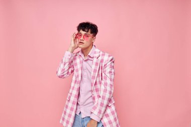 Genç bir adam pembe gözlüklü, kareli ceket modasında pembe arka plan değiştirilmemiş.