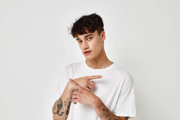 Bello ragazzo moderno stile giovanile bianco t-shirt tatuaggio sul braccio modello studio — Foto Stock