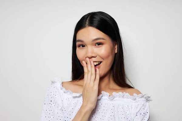 Pretty brunette asian appearance in white shirt light background — Stok fotoğraf