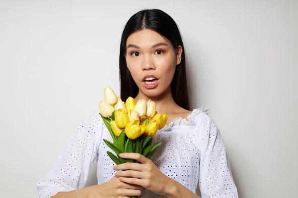 꽃 다발을 들고 있는 아시아인아름다운 젊은 여성의 초상화 변경되지 않은 스튜디오 모델 미소를 클로즈업 — 스톡 사진