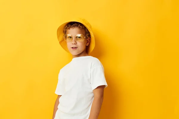 Niño en sombrero amarillo con gafas niños moda fondo amarillo — Foto de Stock