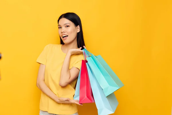 Vrouw met aziatische verschijning vrouw met pakketten in handen winkelen geïsoleerde achtergrond ongewijzigd — Stockfoto