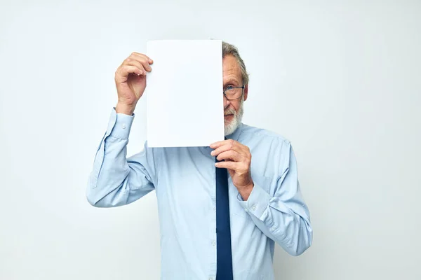 Portrét šťastného staršího muže držícího dokumenty s listem papíru světlo na pozadí — Stock fotografie