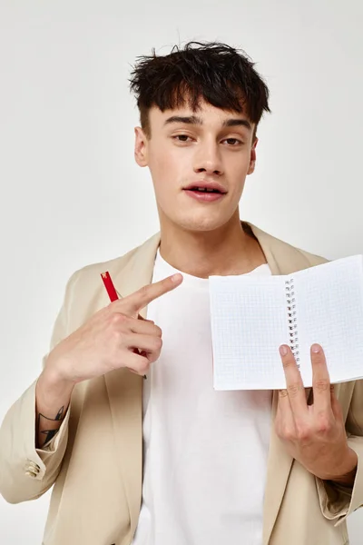 Un joven con un traje beige copia espacio cuaderno luz fondo inalterado —  Fotos de Stock